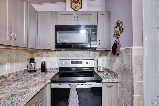 kitchen featuring light stone countertops, backsplash, gray cabinets, and stainless steel electric stove