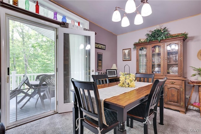 dining space with lofted ceiling, light carpet, and a chandelier