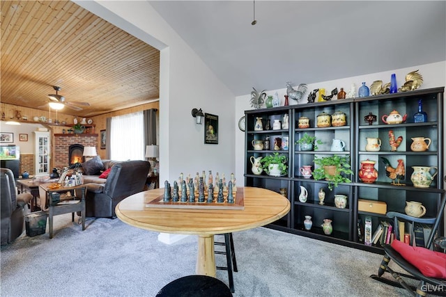 dining space featuring lofted ceiling, carpet floors, ceiling fan, a fireplace, and wood ceiling