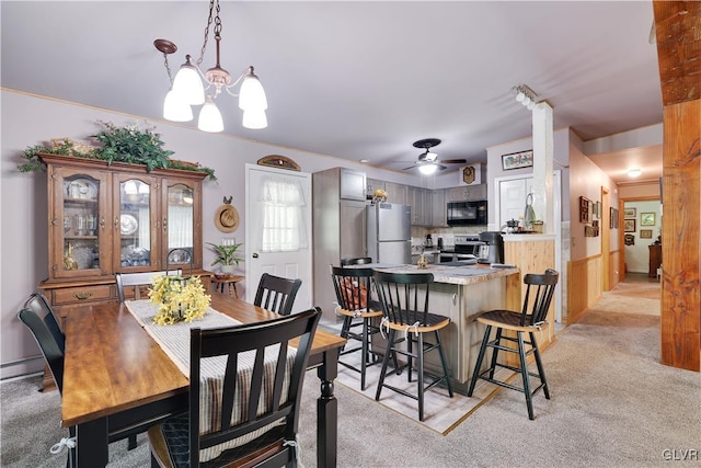 carpeted dining area featuring ceiling fan with notable chandelier and ornamental molding