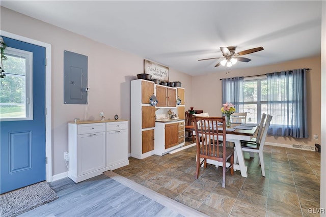 dining room featuring light wood-type flooring, electric panel, and ceiling fan