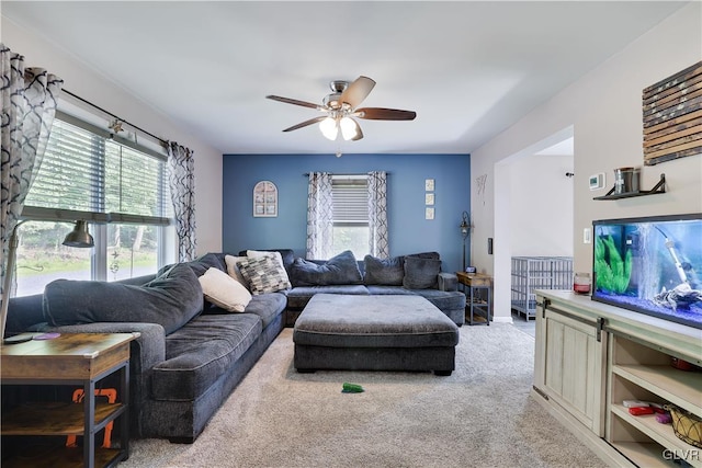 carpeted living room with ceiling fan