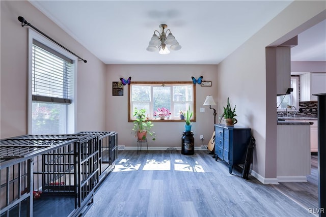 dining area featuring light wood-style flooring, baseboards, a healthy amount of sunlight, and an inviting chandelier