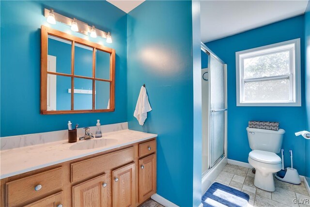 bathroom with vanity, toilet, and a shower with shower door