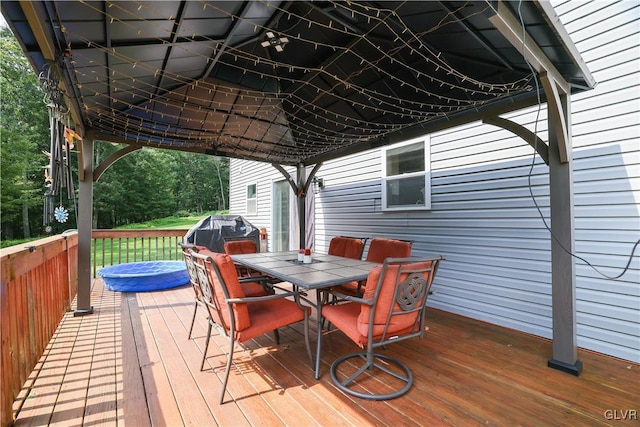 wooden deck with a grill and outdoor dining space