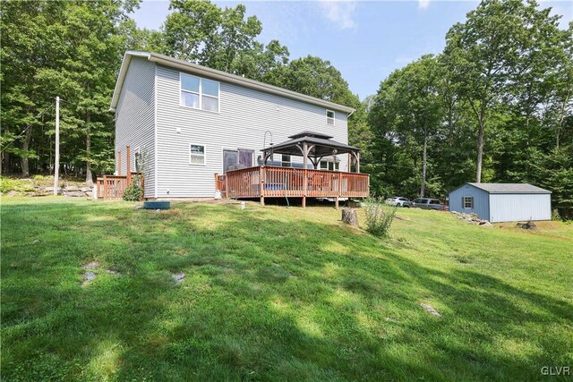 rear view of property with a gazebo, a shed, a wooden deck, and a lawn