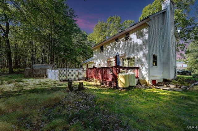 back house at dusk featuring a yard