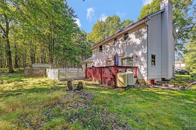 rear view of property featuring a yard and a deck