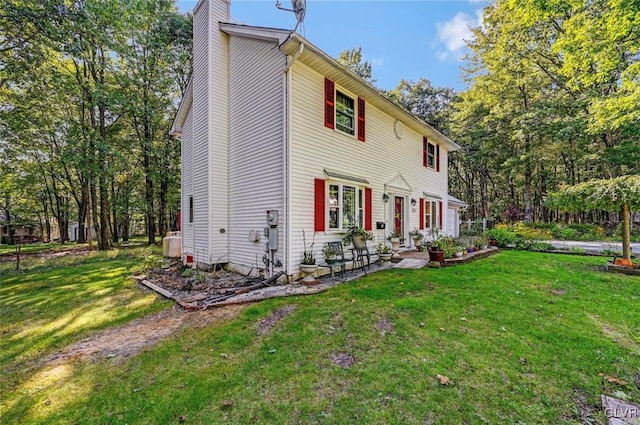 view of property exterior featuring a patio area and a lawn