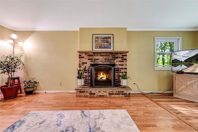 living room featuring hardwood / wood-style floors, a brick fireplace, and crown molding