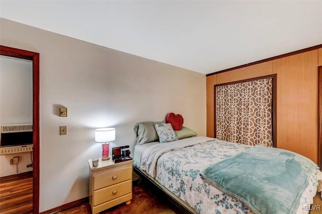 bedroom with dark hardwood / wood-style floors and heating unit