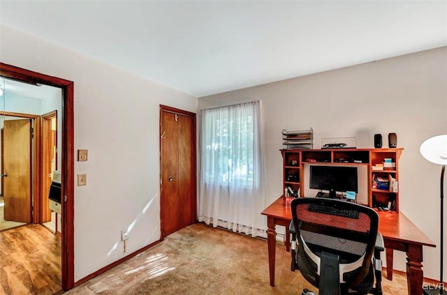 office featuring light carpet and a baseboard radiator