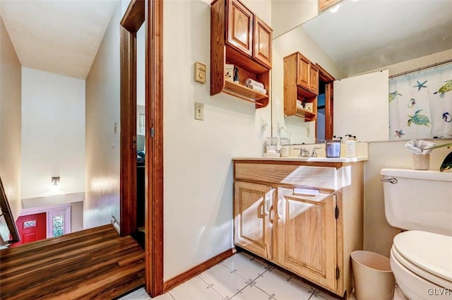 bathroom with tile patterned flooring, vanity, and toilet