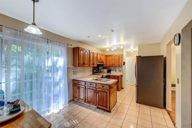 kitchen with tasteful backsplash, light tile patterned flooring, pendant lighting, and appliances with stainless steel finishes