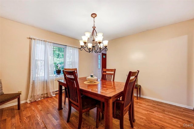 dining room with hardwood / wood-style flooring and a notable chandelier