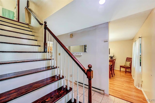 staircase featuring a baseboard radiator and hardwood / wood-style flooring