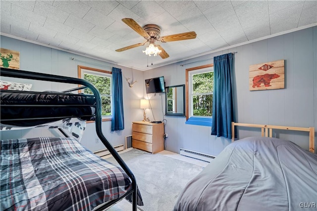 carpeted bedroom with a baseboard heating unit, ceiling fan, and ornamental molding