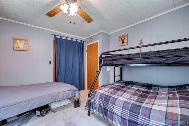 bedroom featuring ceiling fan, ornamental molding, and carpet floors