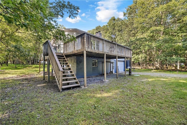 rear view of house with a wooden deck and a lawn