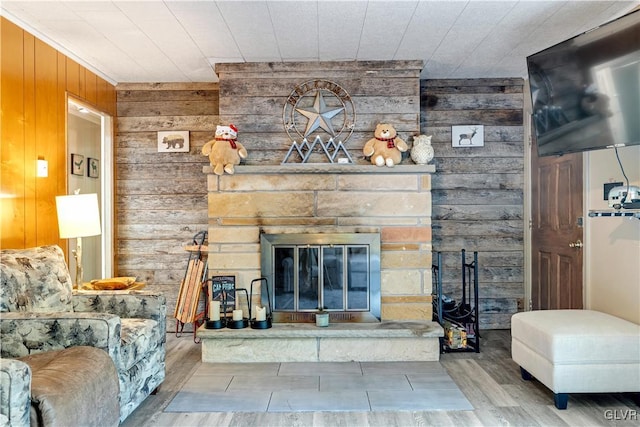 living room featuring wood-type flooring, wood walls, and a fireplace