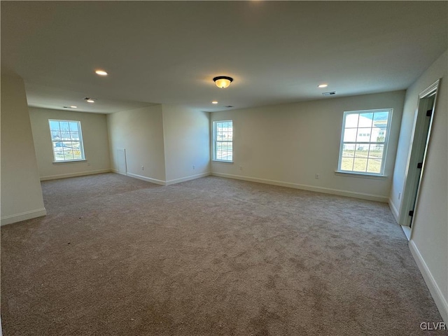 unfurnished room featuring light carpet and a wealth of natural light