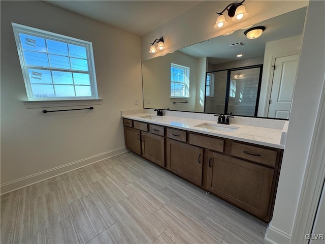 bathroom with vanity and a shower with door