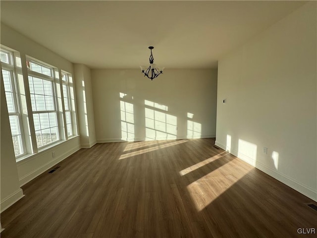 unfurnished dining area with an inviting chandelier and dark wood-type flooring