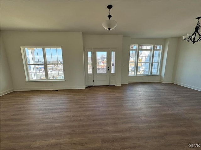 entrance foyer featuring dark hardwood / wood-style floors and a chandelier