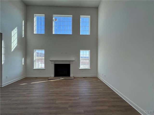 unfurnished living room featuring dark hardwood / wood-style floors and a high ceiling