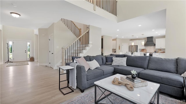 living room featuring light wood-type flooring and a high ceiling