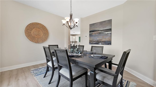 dining area featuring a notable chandelier and light wood-type flooring