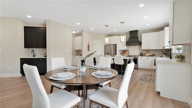 dining space featuring sink and light hardwood / wood-style flooring