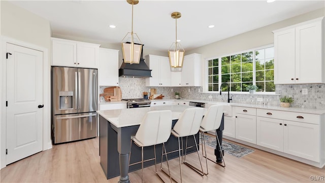 kitchen with premium range hood, stainless steel appliances, and white cabinetry