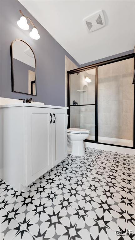 bathroom with a shower with door, toilet, tile patterned floors, and vanity