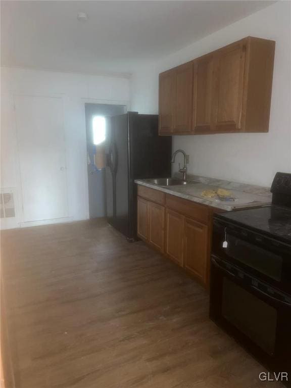 kitchen with electric range, dark hardwood / wood-style floors, and sink