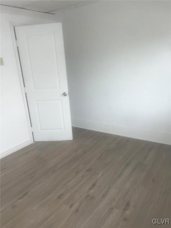 unfurnished room with baseboards and wood finished floors
