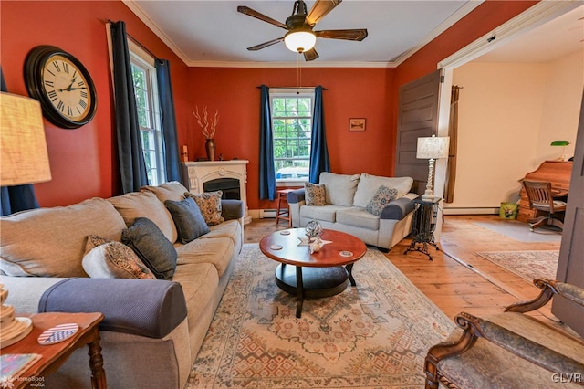 living room with ceiling fan, light hardwood / wood-style flooring, ornamental molding, and a baseboard heating unit