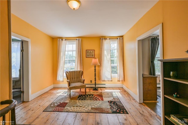 living area featuring a baseboard radiator and light hardwood / wood-style floors