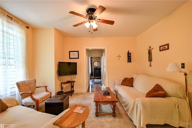 living room featuring ceiling fan, a wealth of natural light, and light carpet