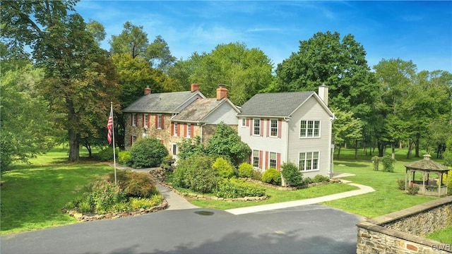 view of front of property featuring a gazebo and a front yard