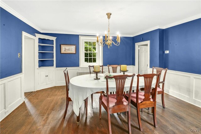 dining room with ornamental molding, an inviting chandelier, and dark hardwood / wood-style floors