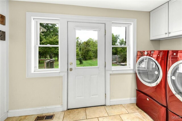 laundry room with independent washer and dryer, light tile patterned flooring, cabinets, and a healthy amount of sunlight