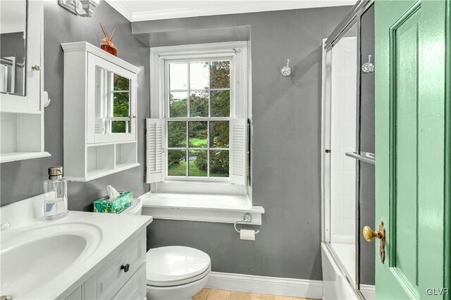 full bathroom with crown molding, toilet, vanity, and combined bath / shower with glass door