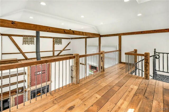 hallway featuring vaulted ceiling and wood-type flooring