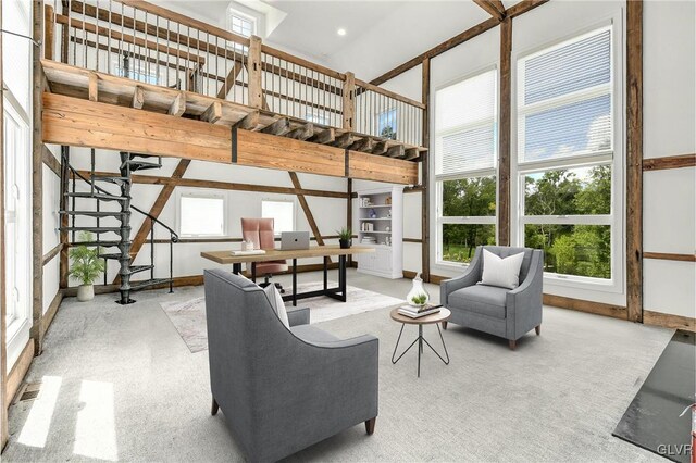 living room with a towering ceiling and light carpet