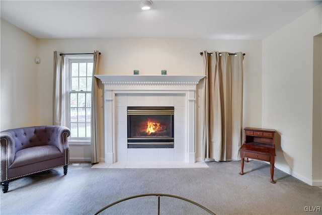 living area with carpet floors, a tile fireplace, and a healthy amount of sunlight