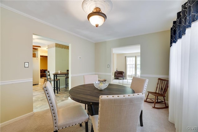 carpeted dining space featuring ceiling fan and crown molding