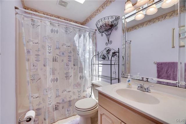 bathroom featuring tile patterned flooring, toilet, walk in shower, and vanity