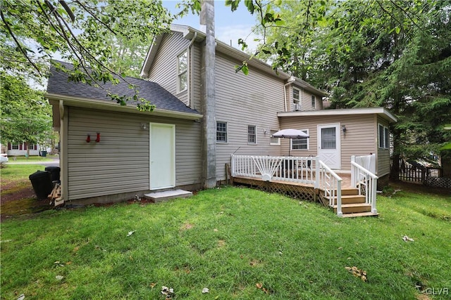 back of property with a yard and a wooden deck