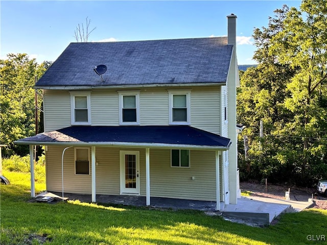 rear view of house featuring a yard